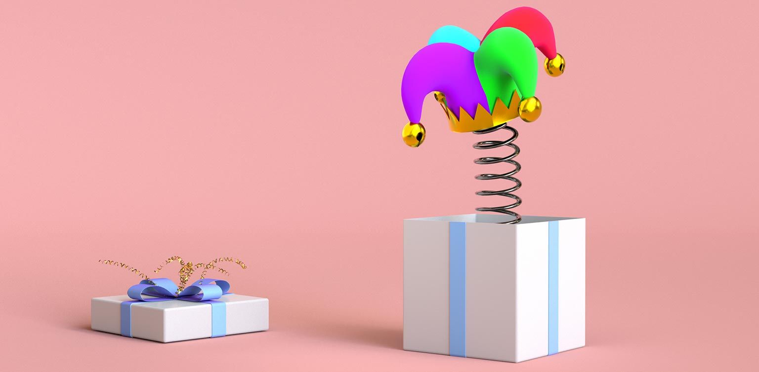 An illustration of an open gift box with a jester’s hat on a coiled spring popping out of it