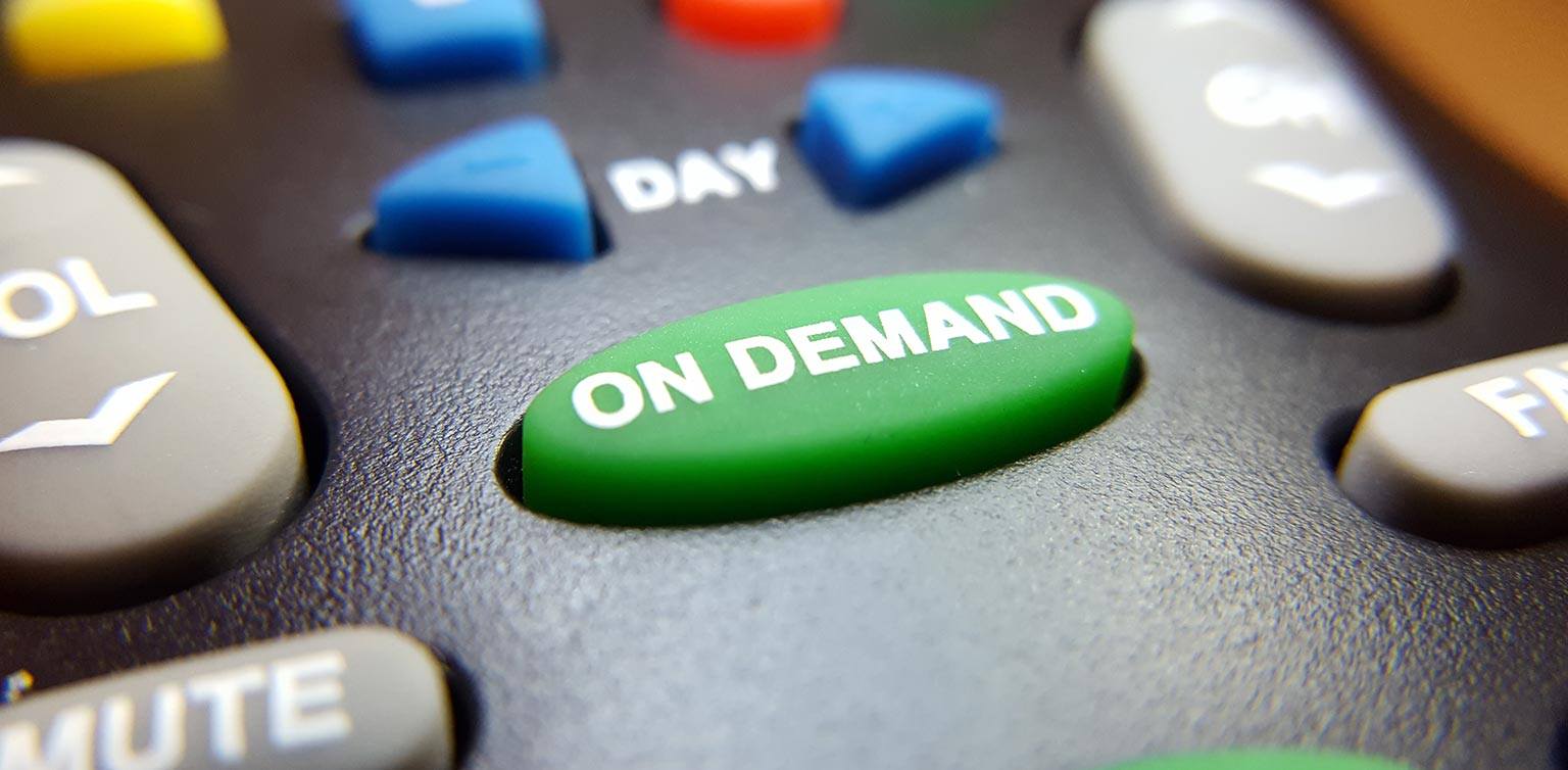 A close-up photo of a TV remote control with a green ‘on demand’ button