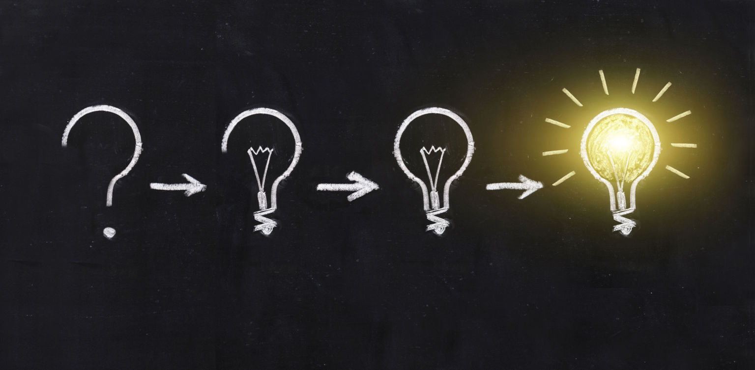 A blackboard with lightbulbs in various stages of completion in white chalk, with a bright shining lightbulb at the end