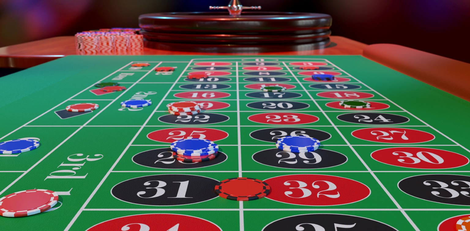 A photographic image of a roulette wheel and layout with casino chips on split and straight up numbers bets