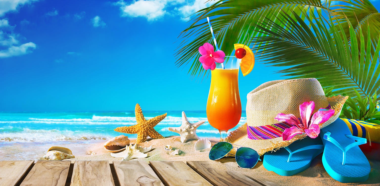 A photo of a Sex on the Beach cocktail with a straw hat, sunglasses, flip flops and shells on a beach boardwalk